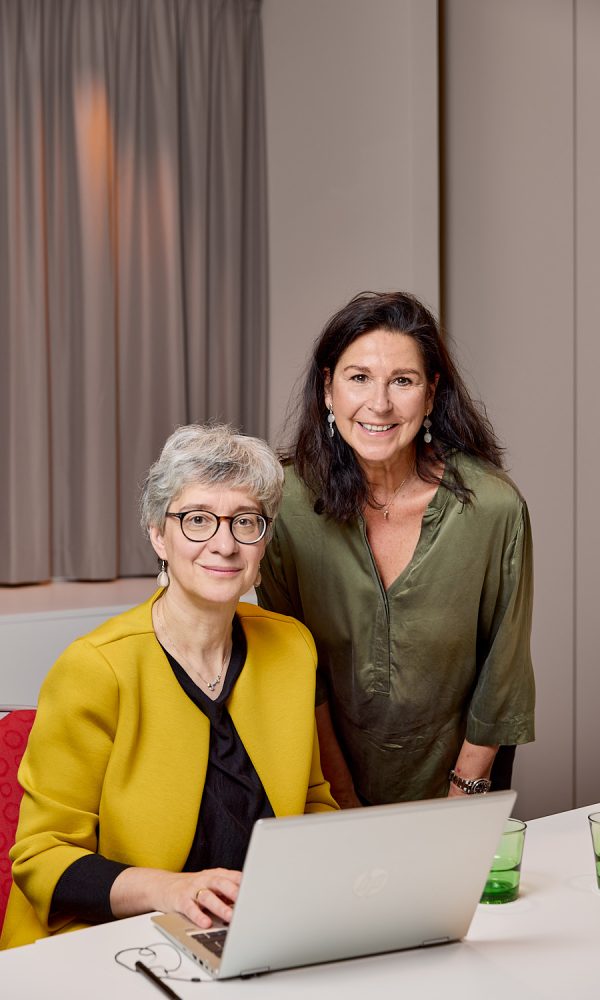 Zwei Frauen mit "MFT Starterpaket - Grundlagen und Praxis" an einem Tisch, mit einem Laptop.